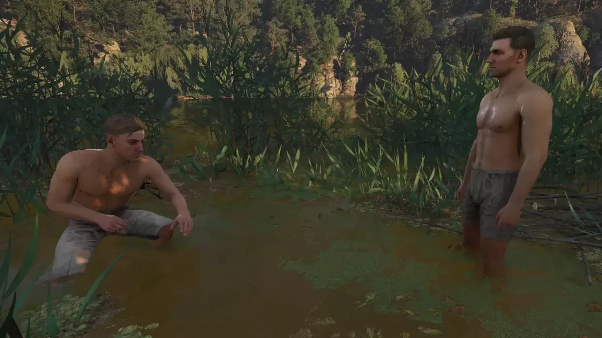 Hans and Henry in Kingdom Come: Deliverance 2, with Henry crouching in the reeds, and Henry standing, both in their pants.